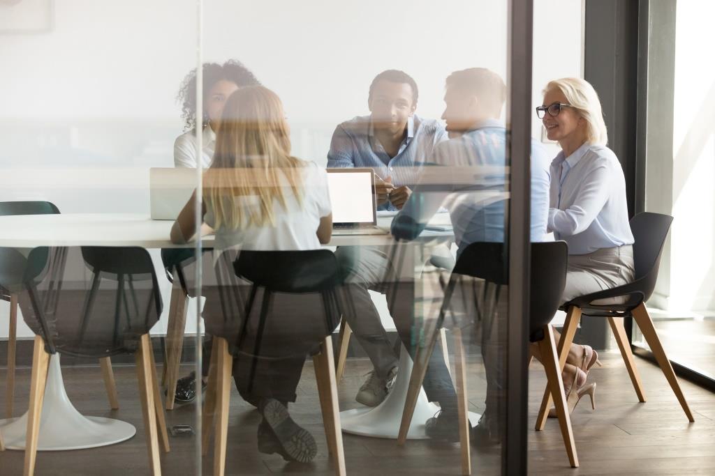 Multiethnic employee brainstorm discuss ideas together in boardroom